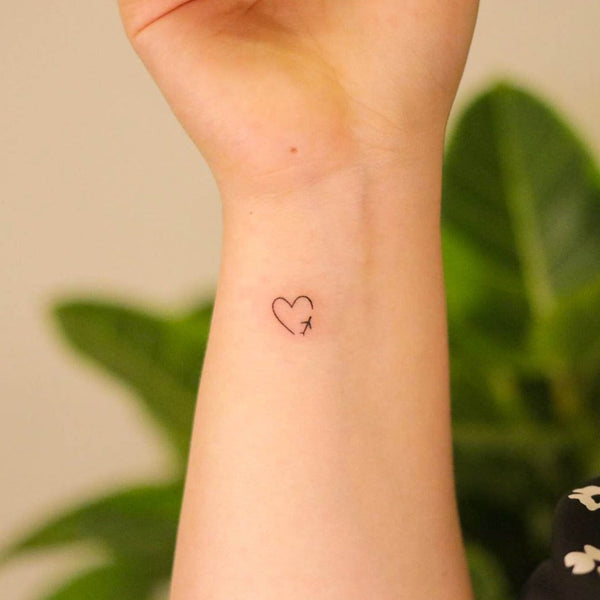 Matching minimalistic heart tattoo for couple.